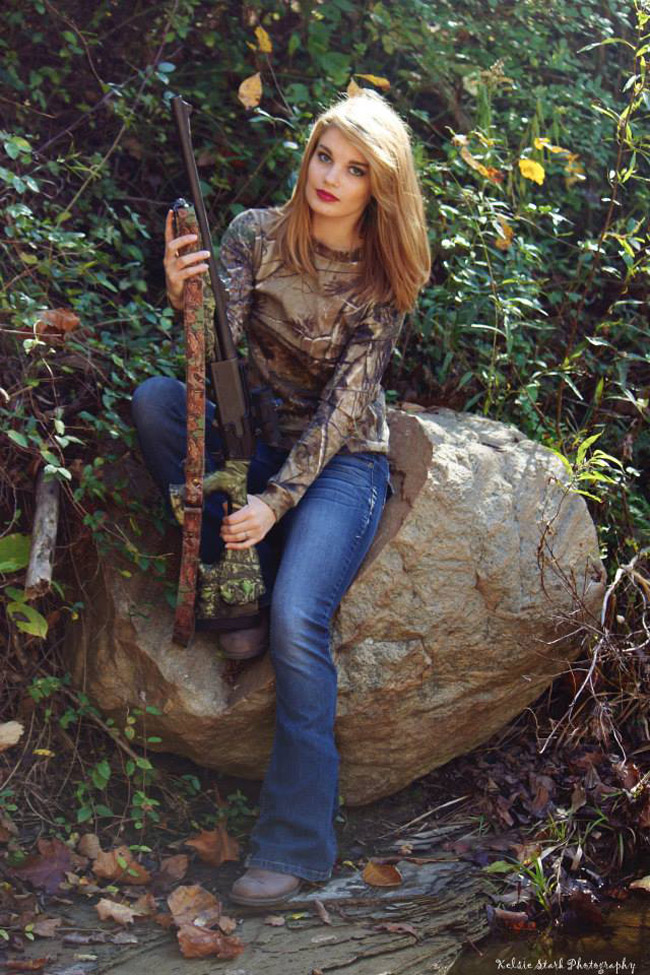Girl sitting on rock holding a gun